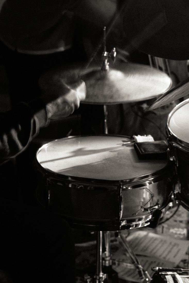 Drum kit mid-hit, black and white